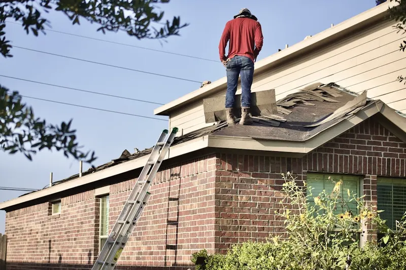 Professional roofer working on a residential roof in Badger